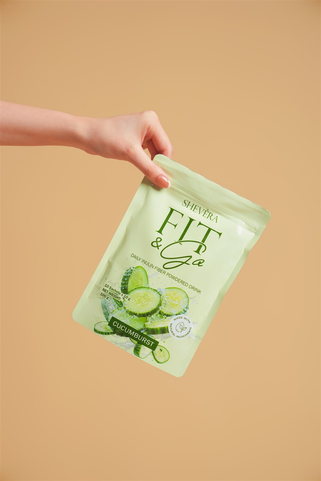 A hand holding a Shevéra Fit and Go Cucumburst pouch